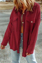 Burgundy textured shacket with raw edge detailing and buttoned pockets.