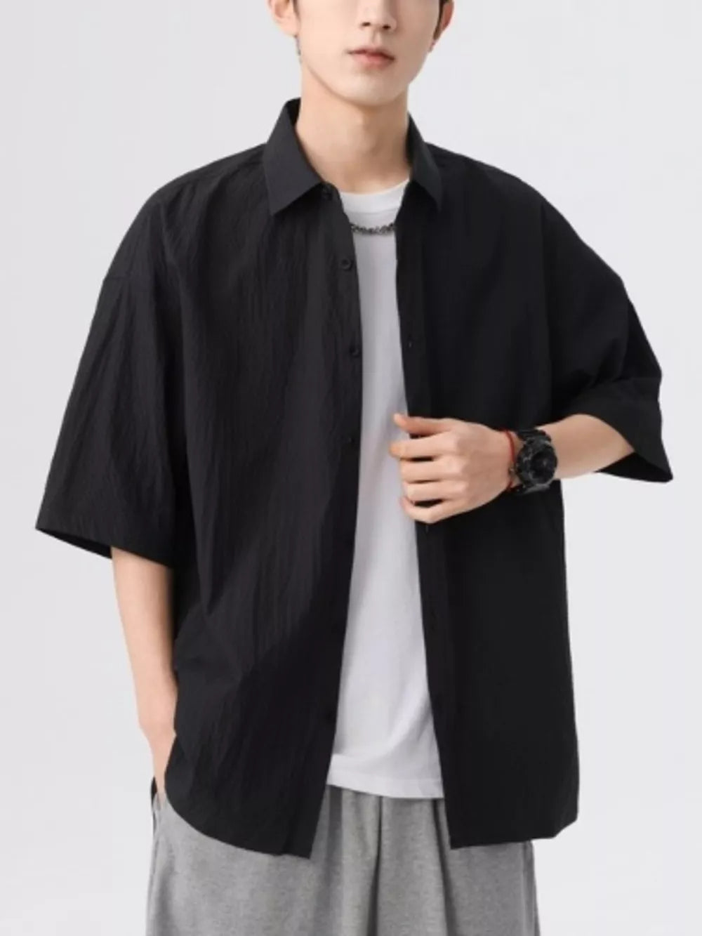 Black textured short-sleeve men's button-up shirt with a relaxed fit.