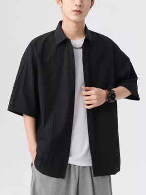 Black textured short-sleeve men's button-up shirt with a relaxed fit.
