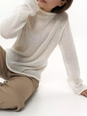 Sheer white mock neck knit sweater with draped fit and long sleeves.