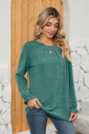 Teal knit top with pleated yoke and ruffled cuffs, crew neck, long sleeves.