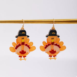 Thanksgiving turkey charm dangle earrings in orange acrylic with black pilgrim hats.