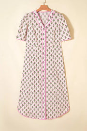 Floral V-neck midi dress with button front, scalloped trim, and short sleeves in blush pink.