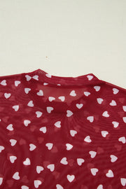 Deep red sheer t-shirt with white heart print and mock neck detail.