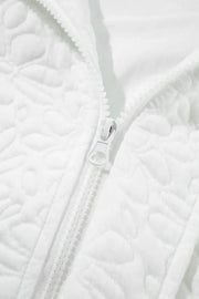 White bomber jacket with all-over quilted floral pattern and white zipper detail.