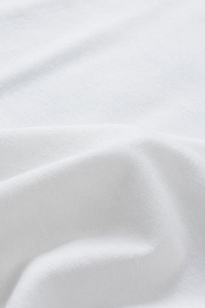 White graphic t-shirt with floral accents, close-up of fabric texture.