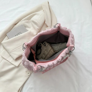 Blush pink shopper bag with textured grid and pearl chain detail, open to show interior.