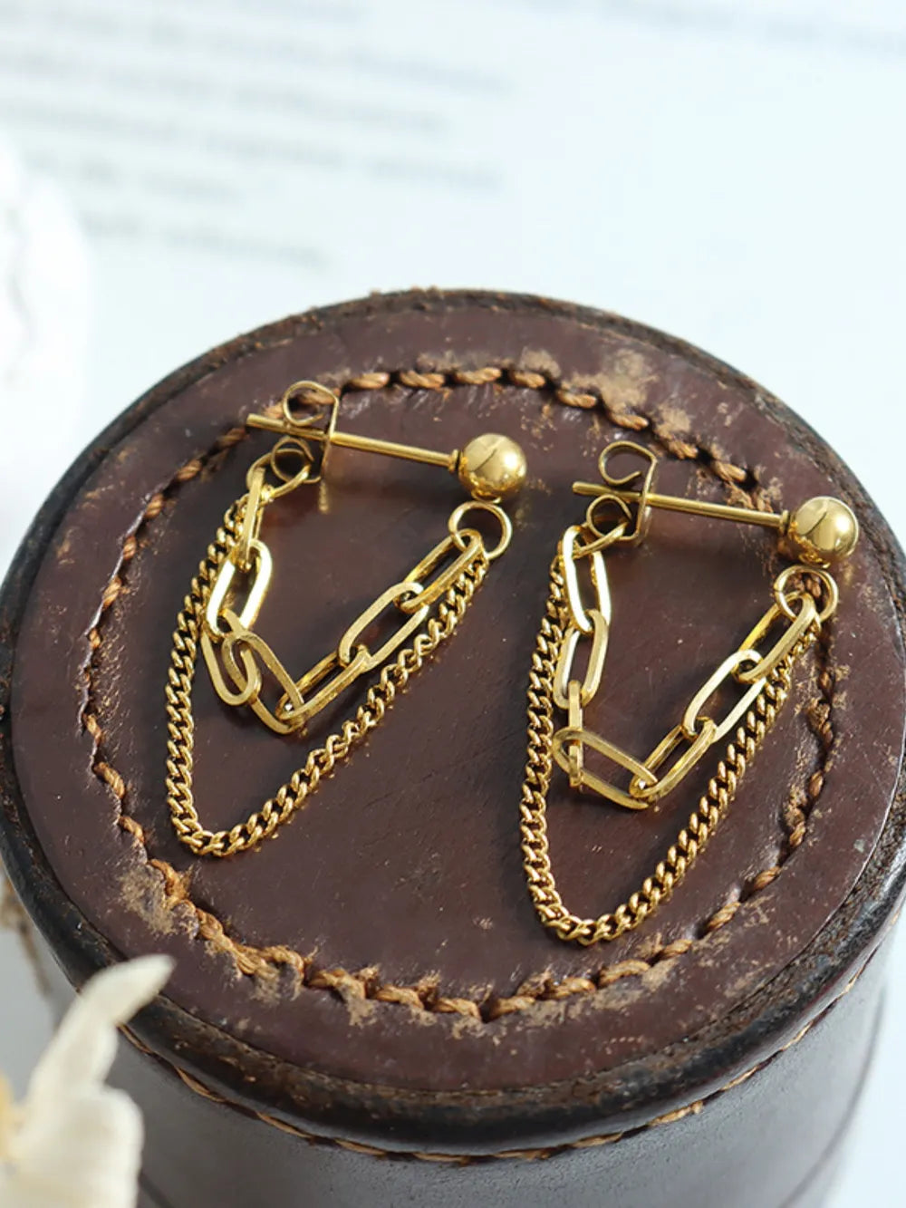 Gold interlocking chain drop earrings with a layered chain design.