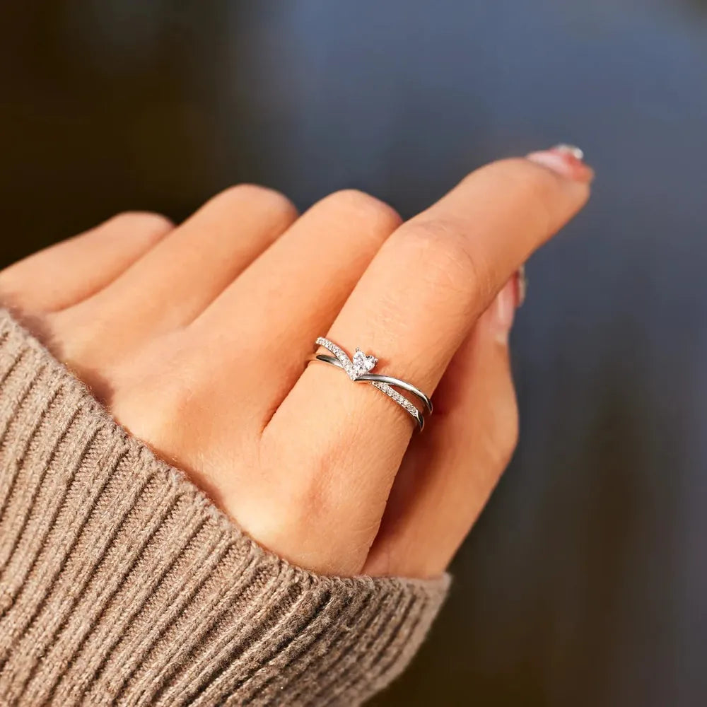 Silver V-shaped ring with diamond accent and pave band detail.