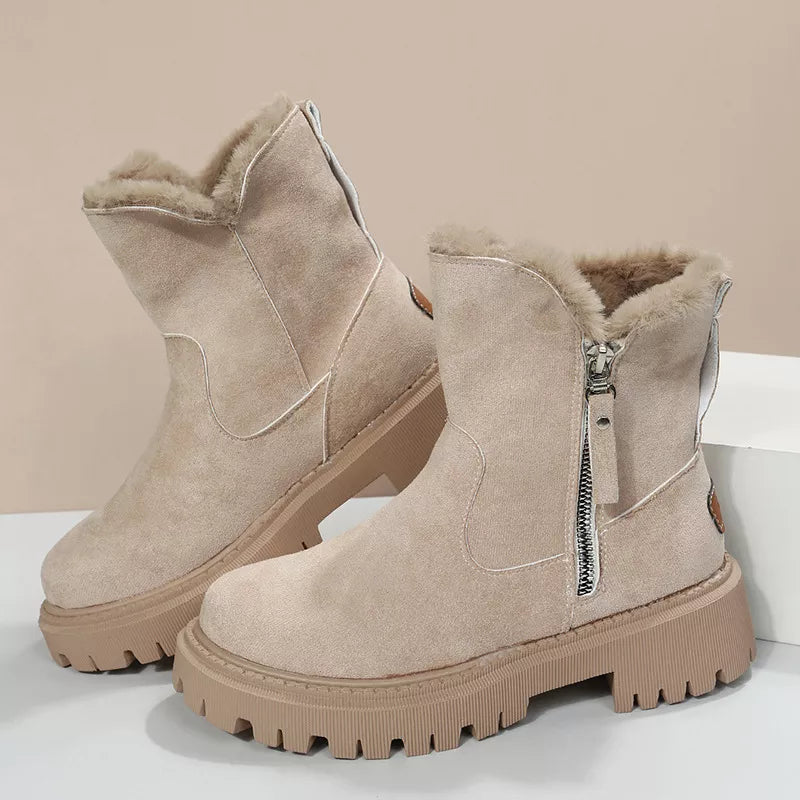 Creamy-white suede ankle boots with faux fur lining and side zipper detail on a chunky sole.