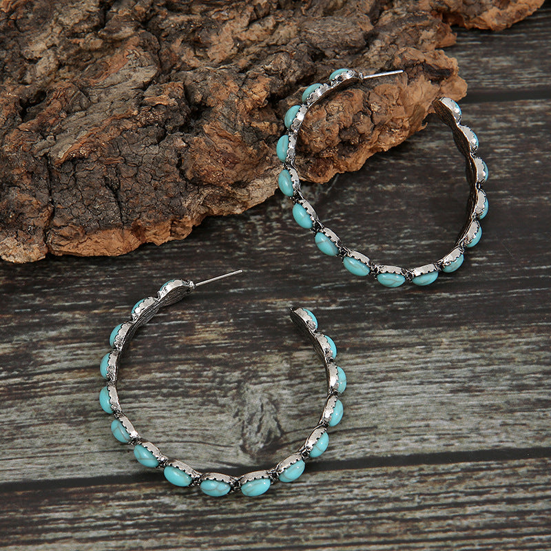 Textured turquoise stone hoop earrings with silver-tone alloy setting.