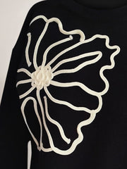 Black long sleeve sweater with white floral embroidery detail