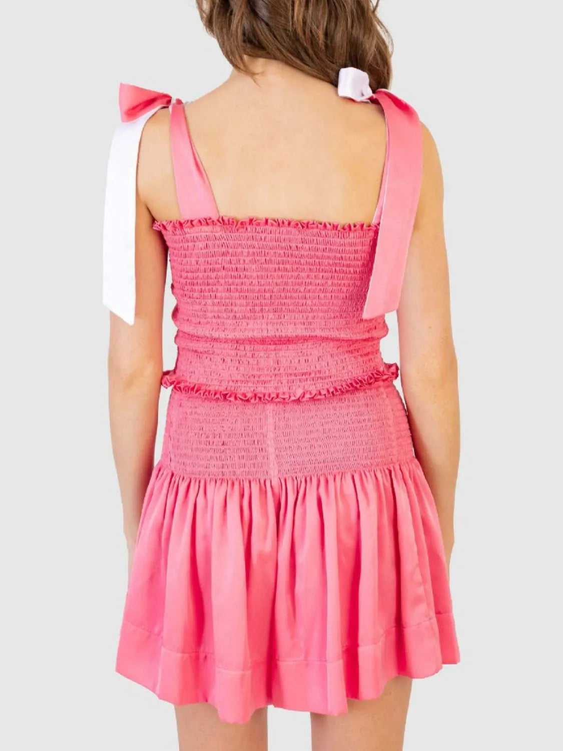 Smocked bodice and skirt set in strawberry pink with tie shoulder straps and ruffled trim.
