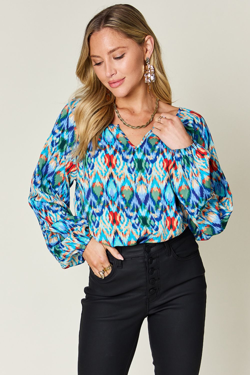 Prismatic ikat blouse in green and blue with voluminous sleeves and v-neck.