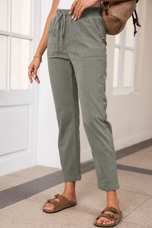 Corduroy drawstring trousers in dark green with slant pockets and a relaxed fit.