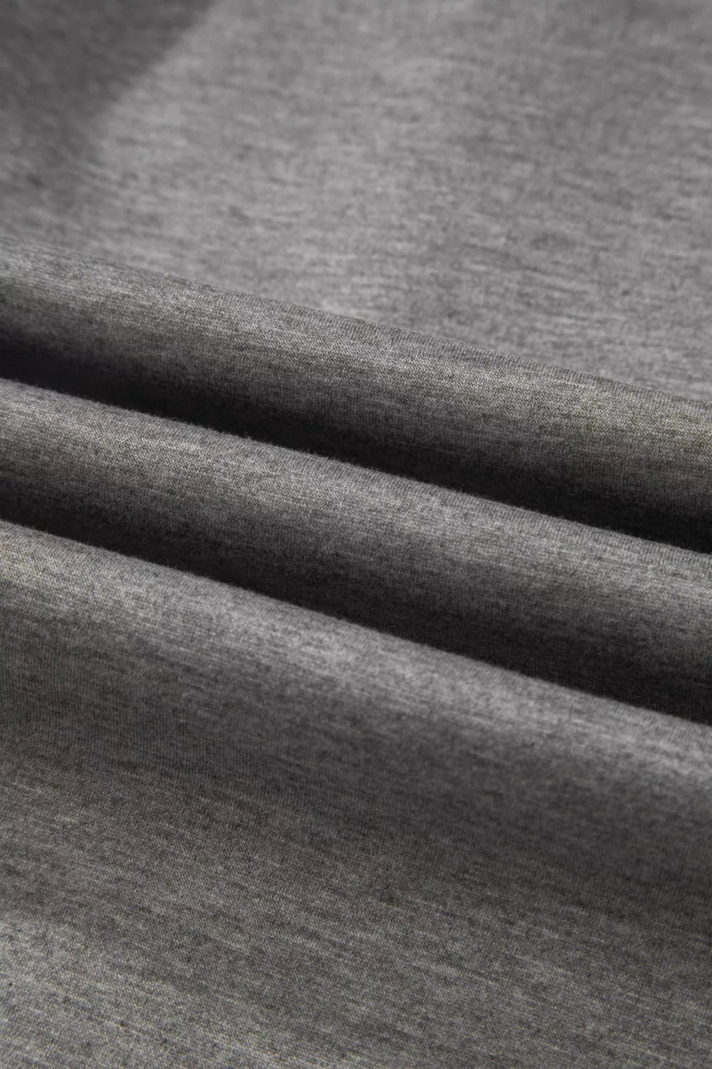 Dark gray knit fabric detail of a chic half-zip polo and wide-leg set.