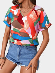 Geometric print V-neck blouse with short sleeves in multicolor.