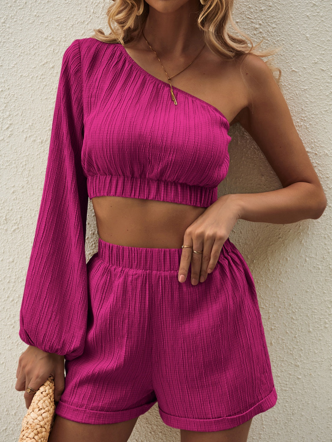 Textured one-shoulder crop top and cuffed shorts set in magenta