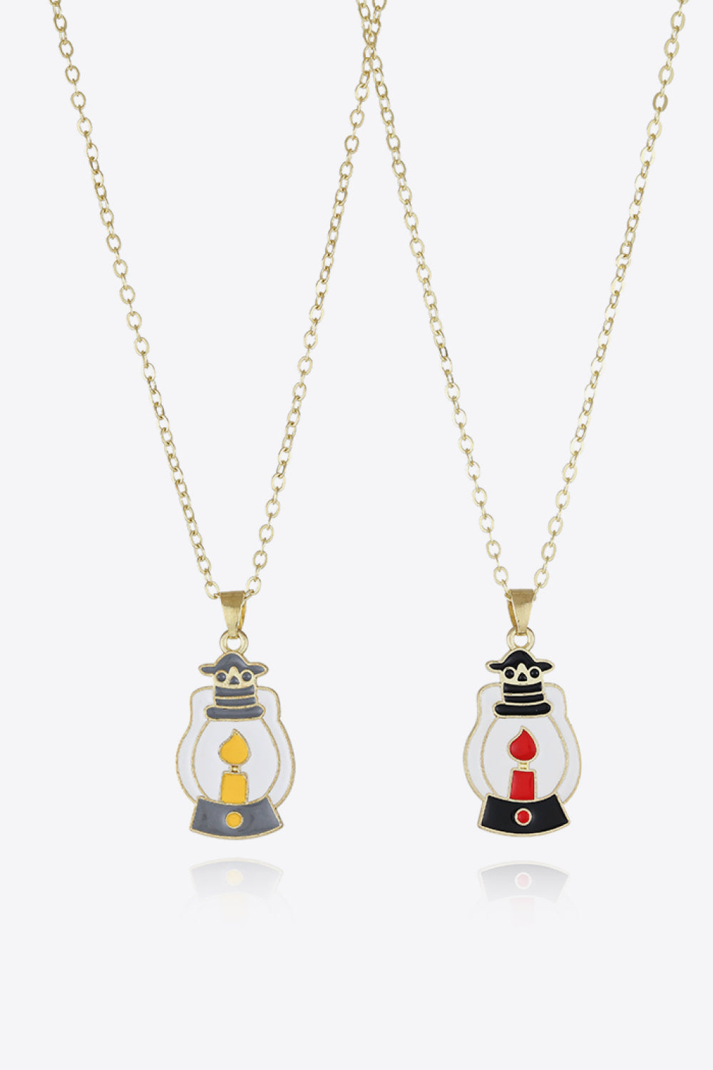 Spooky Season enamel pendant necklaces, one with yellow candle, one with red candle.