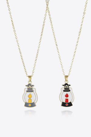 Spooky Season enamel pendant necklaces, one with yellow candle, one with red candle.
