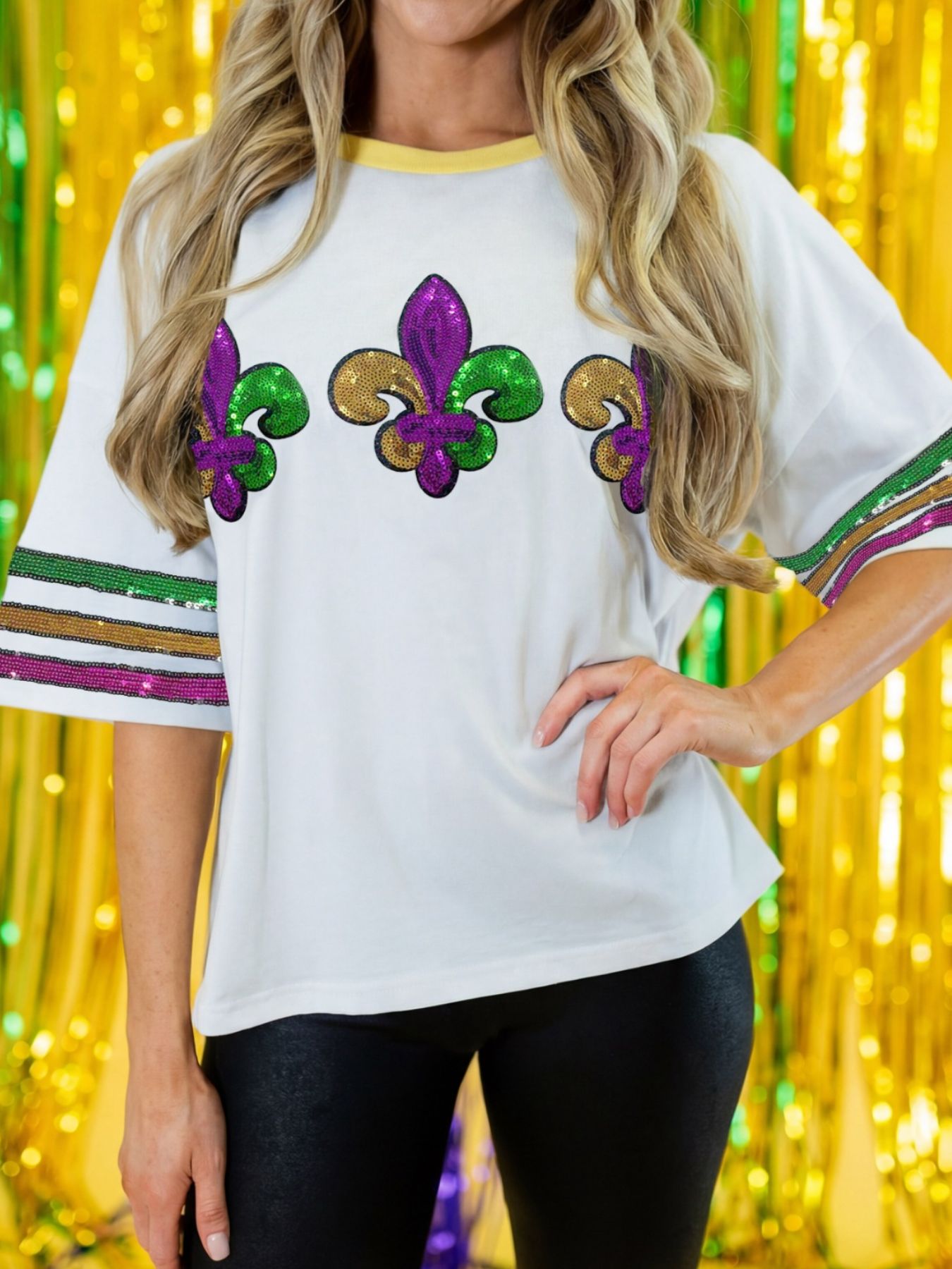 White cotton t-shirt with sequin Mardi Gras fleur-de-lis and striped sleeves.