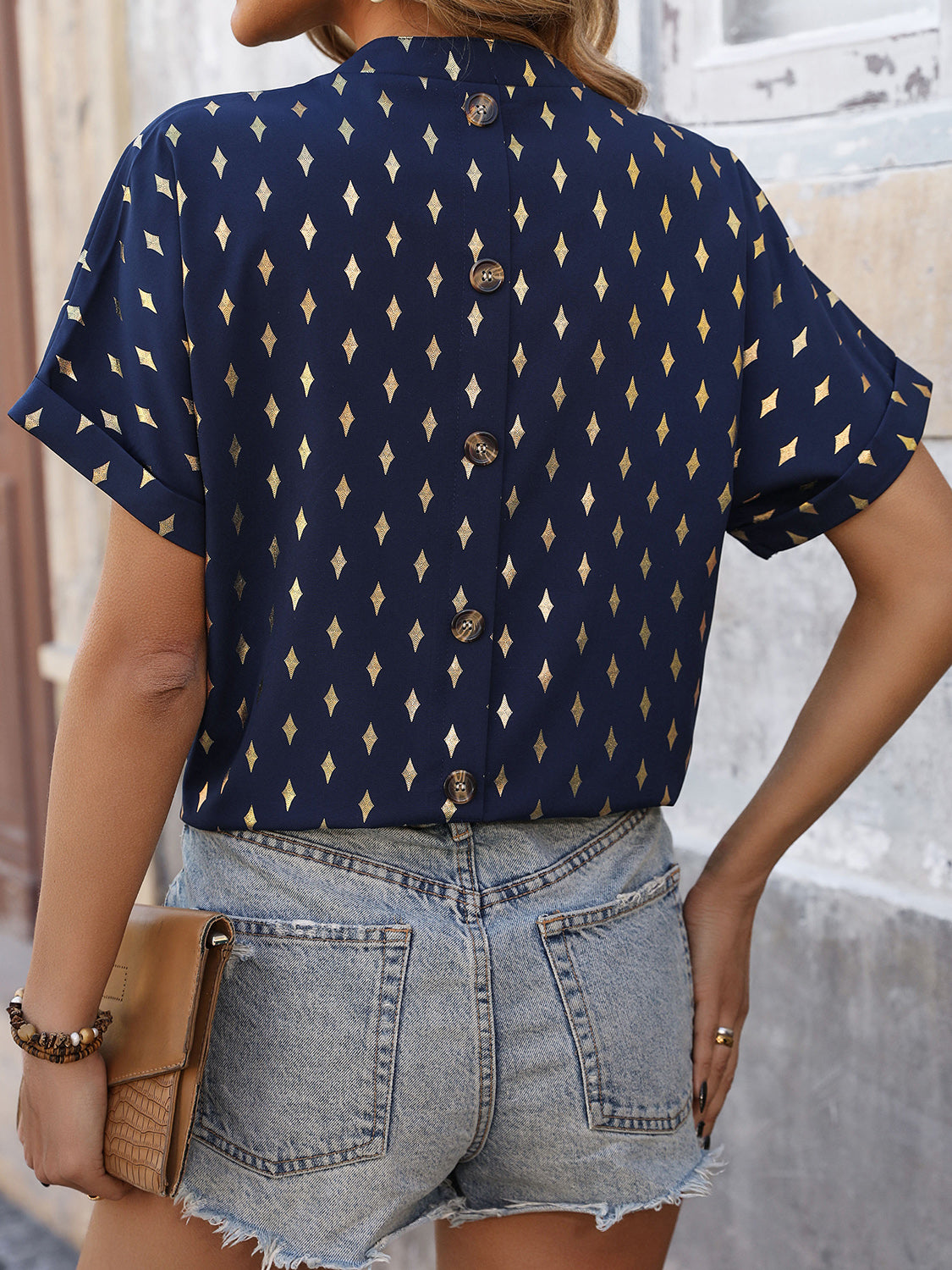 Dark blue short sleeve blouse with gold diamond print and button back detail.