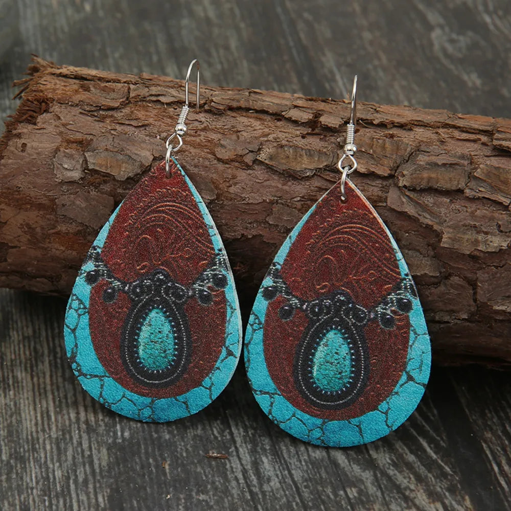 Cowhide teardrop earrings with turquoise and brown western pattern.