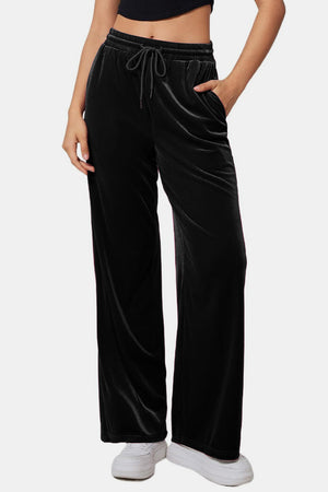 Black velvet palazzo lounge trousers with drawstring waist and pockets.