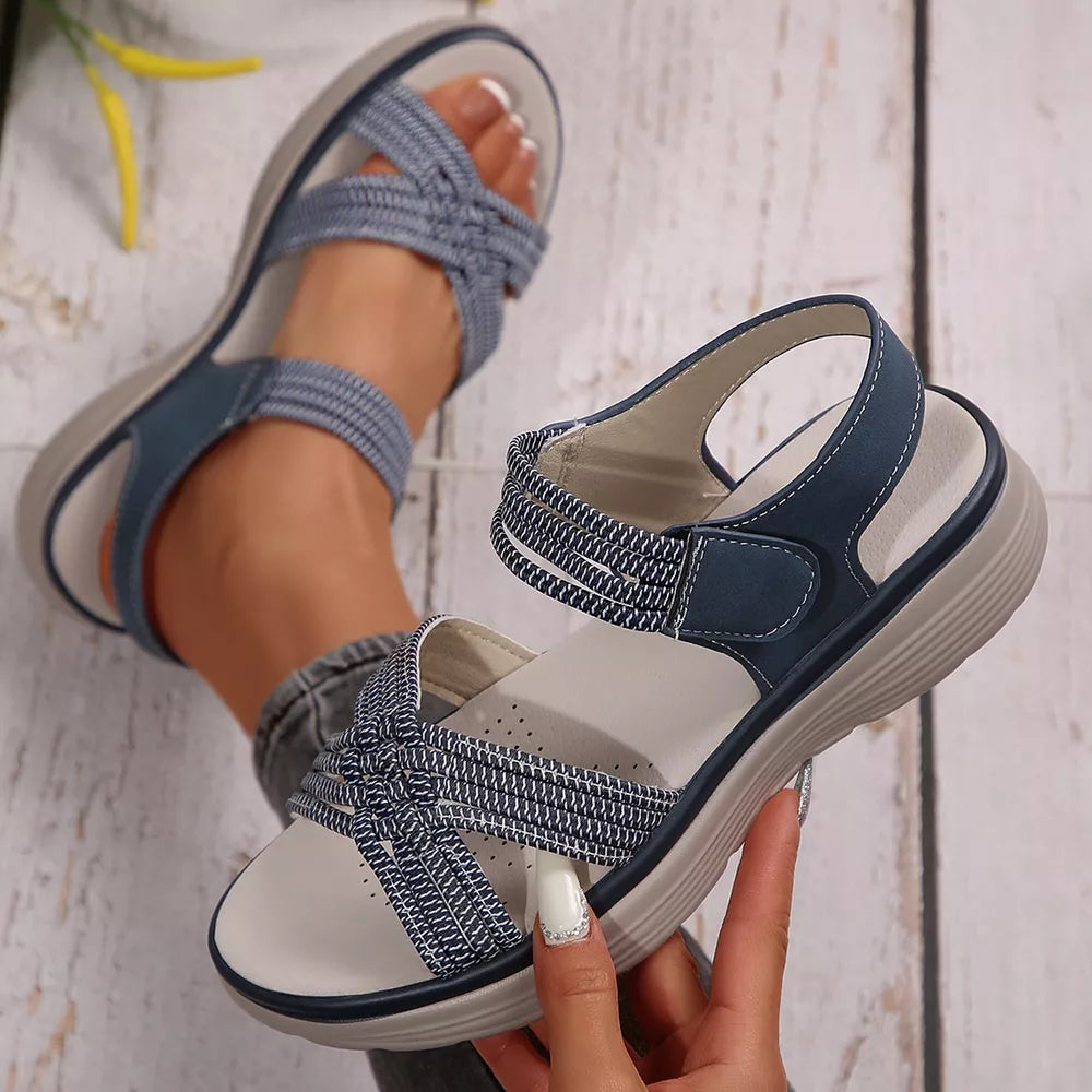 Blue woven criss-cross platform sandals with adjustable straps and cushioned footbed.