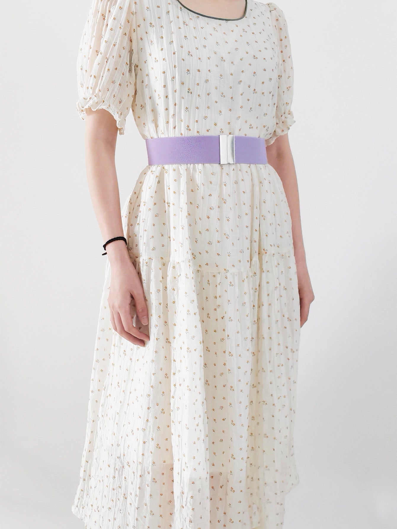 Lavender elastic belt with silver clasp detail worn with a floral dress