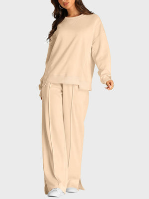 Seamed lounge set in tan with crew neck sweatshirt and slit-front wide-leg trousers.