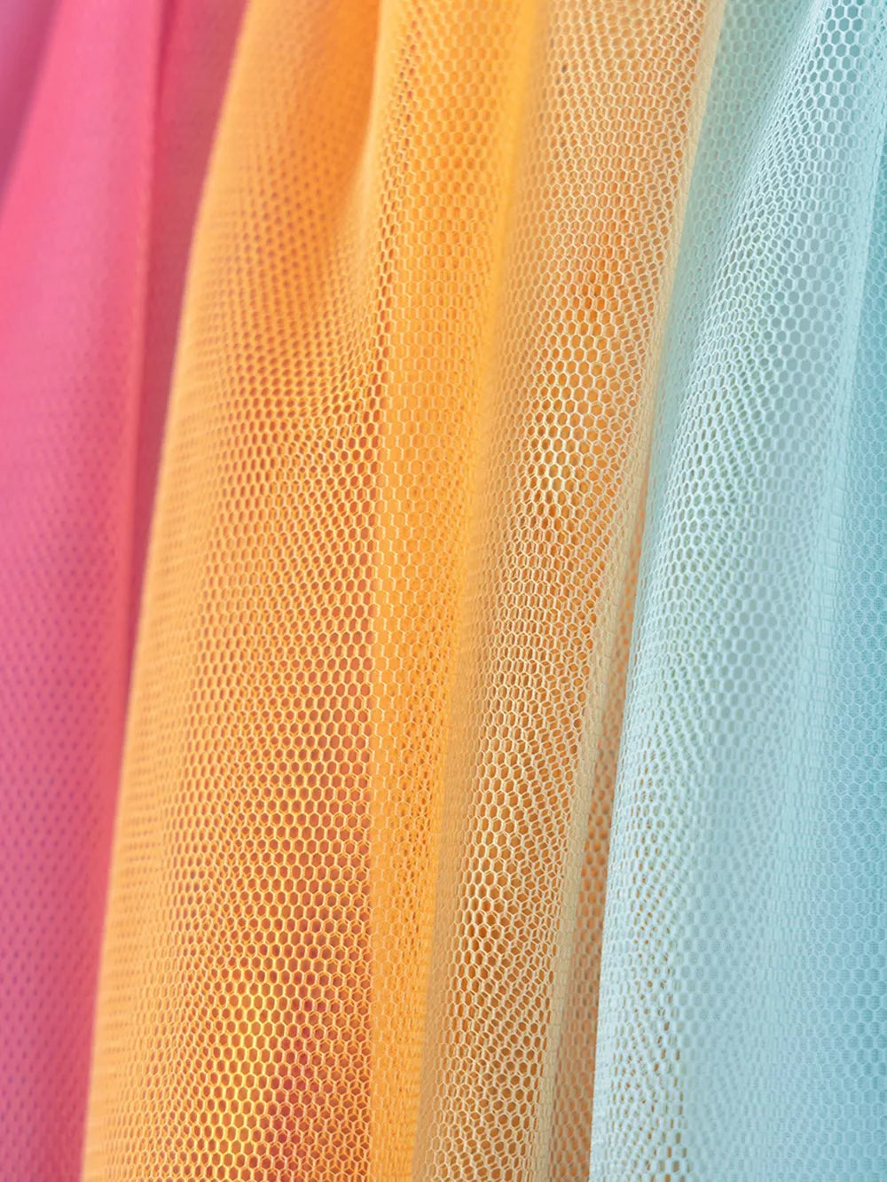 Toddler rainbow tulle dress fabric detail in pink, orange, and blue.