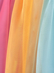Toddler rainbow tulle dress fabric detail in pink, orange, and blue.