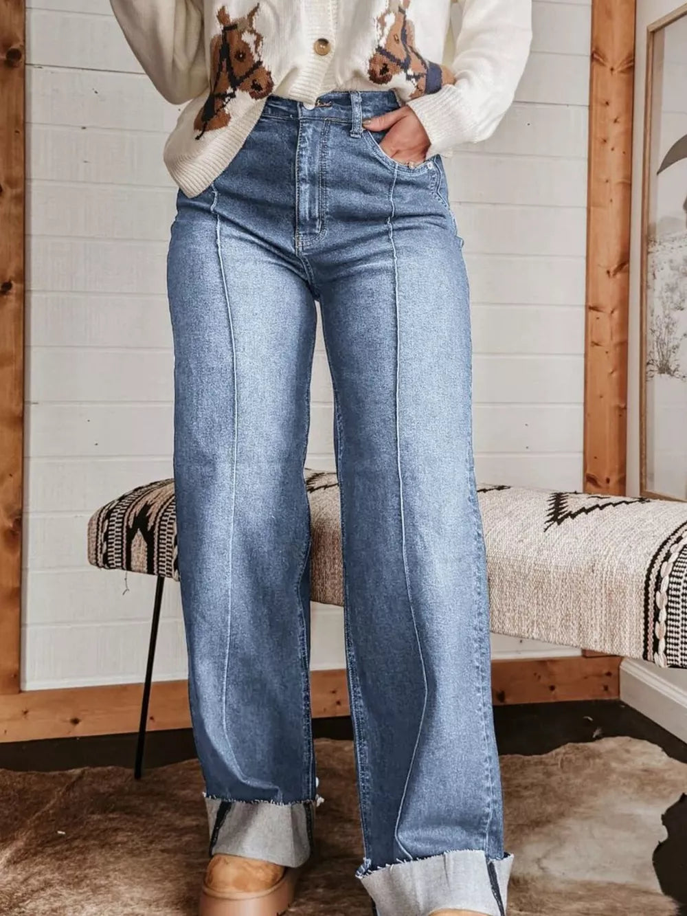 Light blue denim wide-leg jeans with buttoned pockets and cuffed hems.