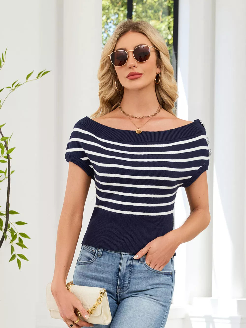 Chic navy and white striped knit sweater with decorative shoulder buttons and off-the-shoulder neckline.
