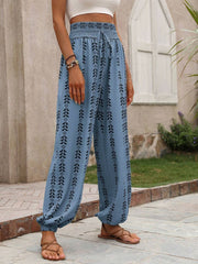 Cerulean ankle trousers with indigo leaf print, gathered waist and cuffs, and drawstring.