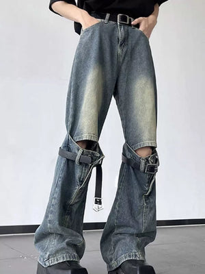 Distressed blue cotton wide-leg jeans with decorative straps and cutouts.