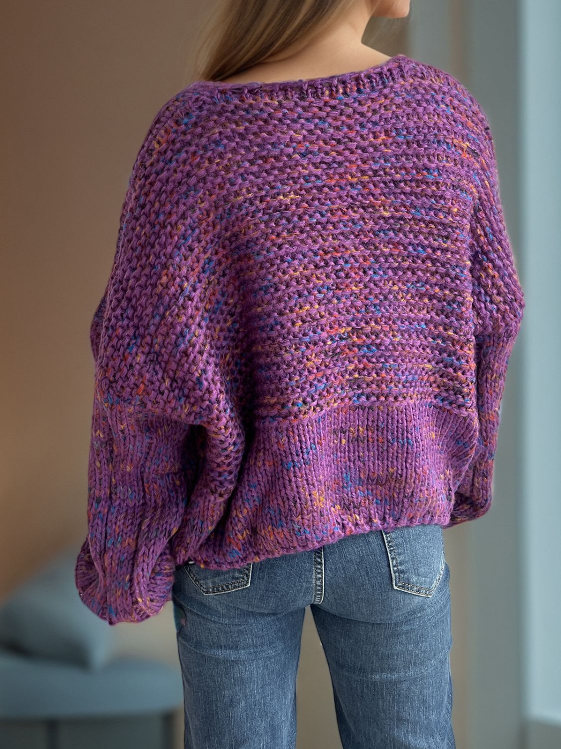 Purple speckled knit sweater with balloon sleeves and a boat neck.