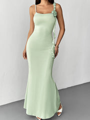 Ruffled mermaid maxi dress in light green with spaghetti straps and a floral detail.
