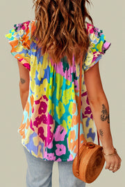 Floral patchwork blouse with ruffle sleeves in a vibrant abstract print.