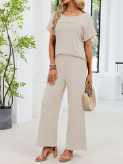 Beige lace cutout waffle knit two-piece set with wide leg pants and short sleeve top.