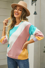 Geometric colorblock knit crewneck sweater with diagonal color blocking in pink, white, blue, and yellow.