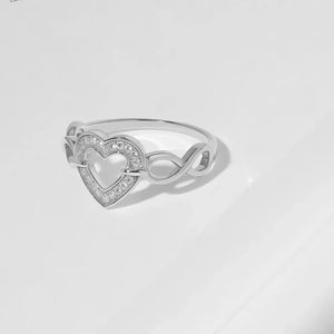 Silver ring with intertwined heart and infinity design, pavé crystal accents.