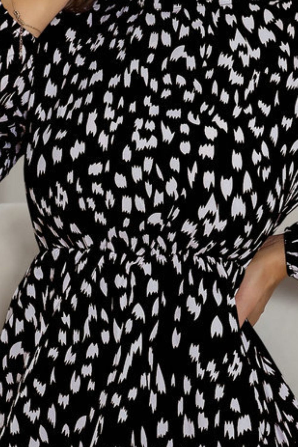 Black dotted print mini dress with gathered waist and long sleeves