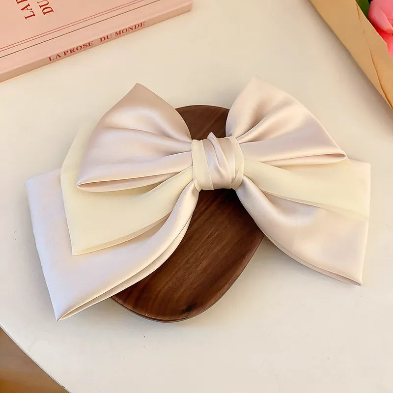 Blush pink and ivory satin bow barrette hair clip with sheer overlay detail.