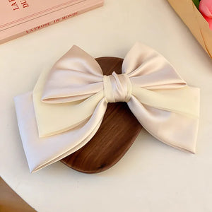 Blush pink and ivory satin bow barrette hair clip with sheer overlay detail.