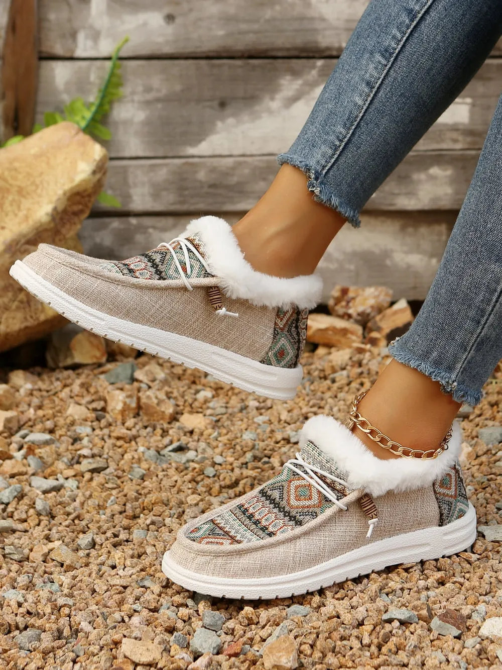 Southwestern print faux fur lined loafers in taupe with white laces and a gold ankle bracelet.