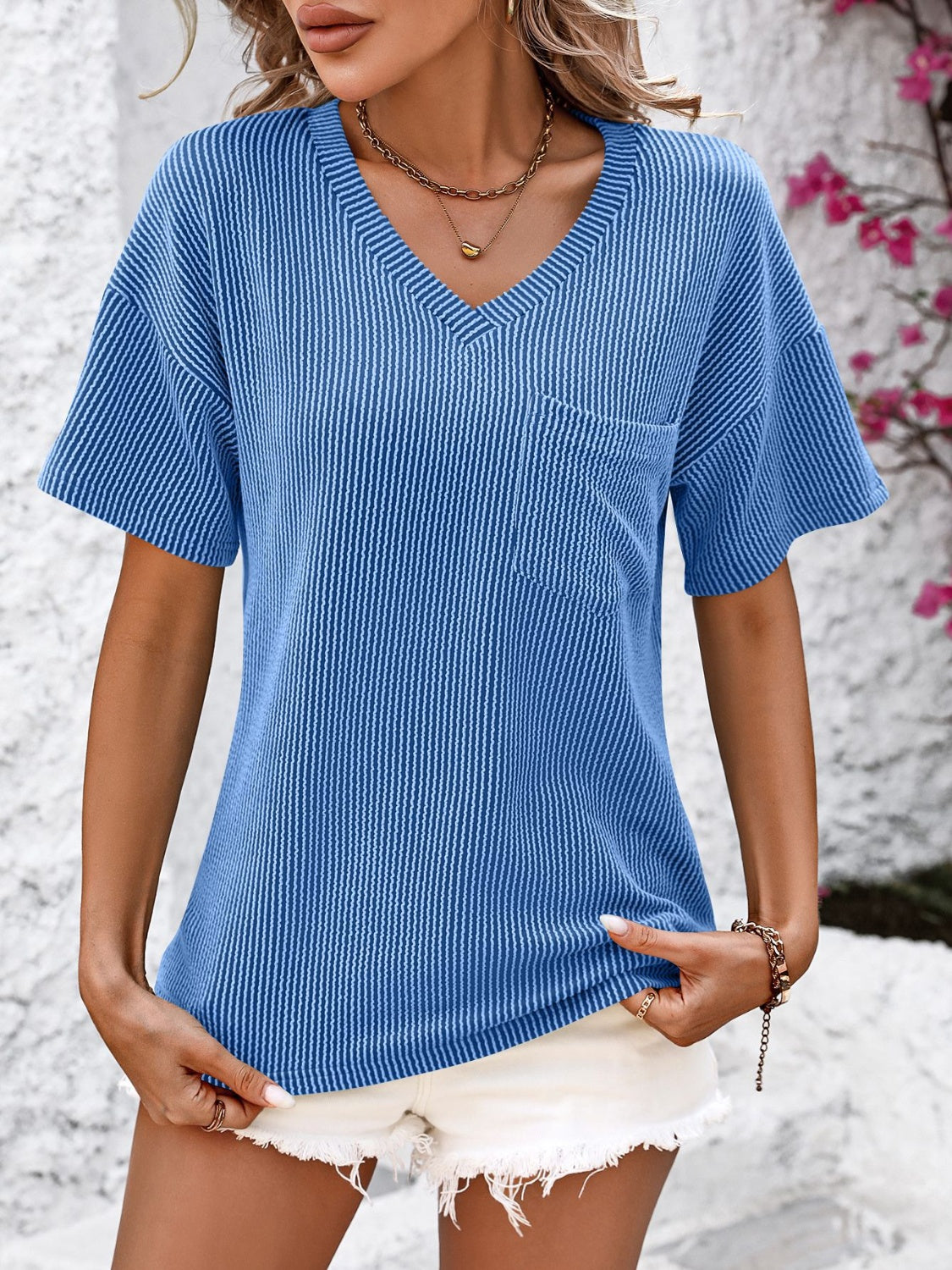 Blue textured ribbed V-neck t-shirt with short sleeves and a chest pocket.