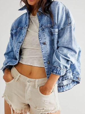 Oversized washed blue denim trucker jacket with button front and chest pockets.