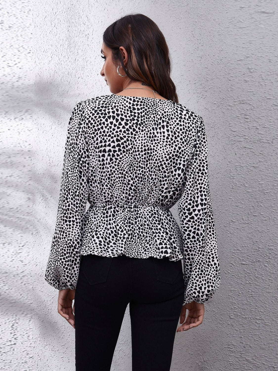 Black and white leopard print peplum blouse with gathered waist and balloon sleeves.